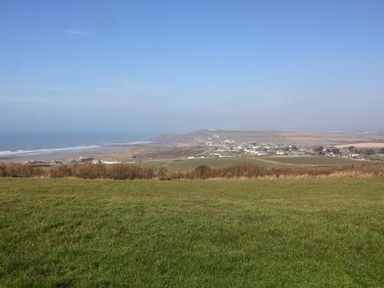 A coastal landscape with green fields a village and ocean at Atlantic Escape in Widemouth Bay