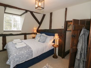 A bedroom with a bed and bedside tables with lamps near a window at Church View in Welford-On-Avon
