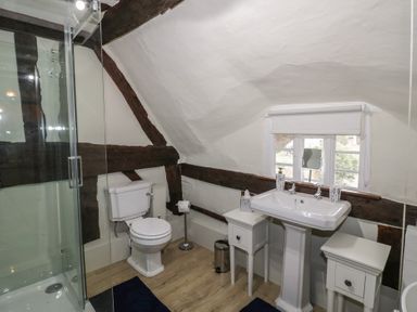 A bathroom with a toilet shower sink and two small cabinets at Church View in Welford-On-Avon