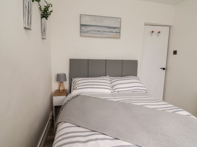 A bedroom with a bed and nightstand at Driftwood in Rhyl