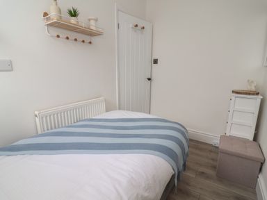 A bedroom with a bed and shelf at Driftwood in Rhyl