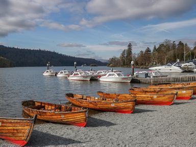 Boats moored at a pier beside a lake at Highfield Cottage in Windermere