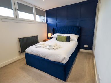 A bedroom with a bed and bedside table at Highfield Cottage in Windermere