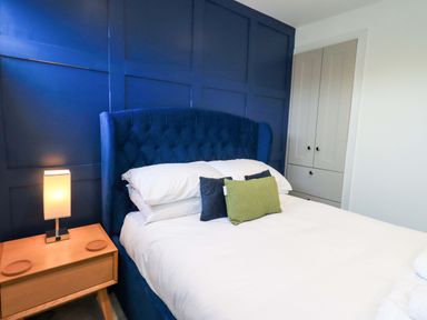 A bedroom with a bed and a lamp at Highfield Cottage in Windermere