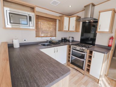 A kitchen with a microwave oven sink stove kettle and cabinets at Lodge 1 in Silverdale