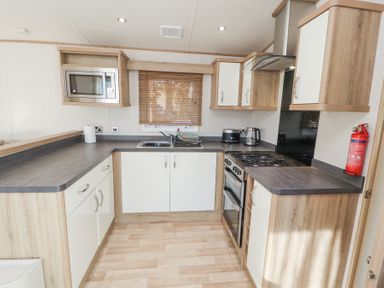 A kitchen with a microwave oven stove and sink at Lodge 1 in Silverdale