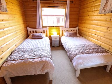 A bedroom with two single beds and a window at Forest Lodge in Kenwick Woods