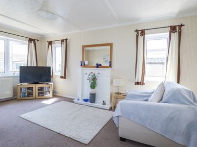 A living room with a television and sofa at Lazy Days in St Merryn