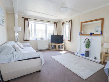 A living room with a sofa and television at Lazy Days in St Merryn