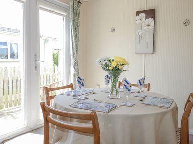 A dining room with a table set for meals at Lazy Days St Merryn
