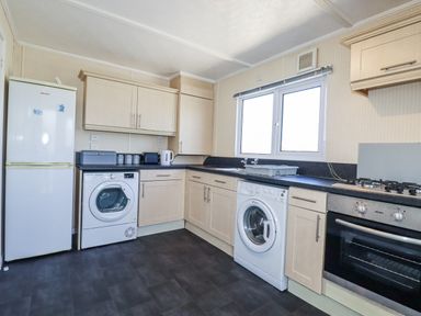 A kitchen with appliances and cabinets at Lazy Days St Merryn