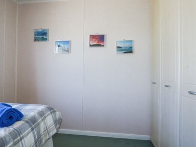 A bedroom with a bed and towels at Lazy Days in St Merryn