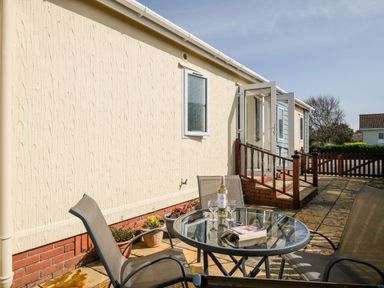 A patio area with a table and chairs at Lazy Days in St Merryn