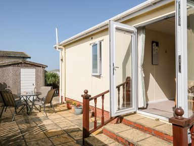 An outdoor patio with a table and chairs at Lazy Days in St Merryn