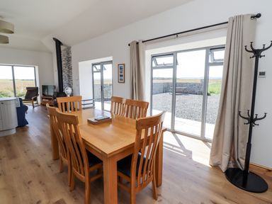 A living room with a dining table and chairs at West Burton Hemmel in Bamburgh