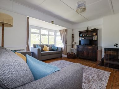 A living room with a sofa and television at Sea Ledge in Tintagel