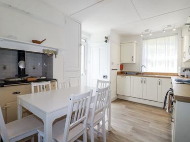 A kitchen with table and chairs at Sea Ledge in Tintagel