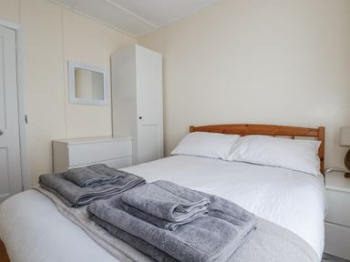 A bedroom with a bed and towels at Sea Ledge in Tintagel
