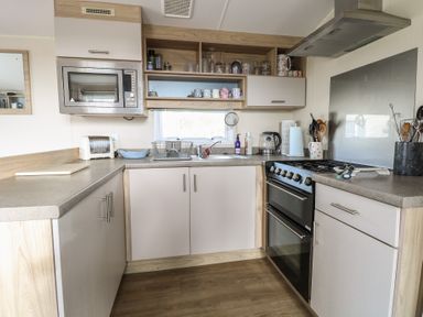 A kitchen with a microwave toaster kettle stove sink and utensils at Breathing Space Happisburgh near Walcott