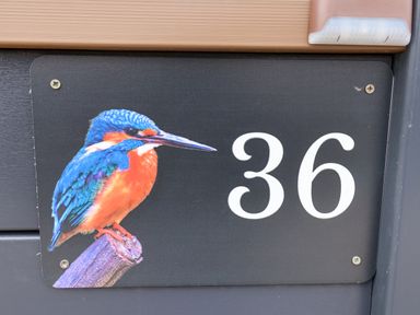 A black house number sign with number 36 and a colorful kingfisher bird at Lodge 36 - Kingfisher Lodge in Wickhamford near Evesham