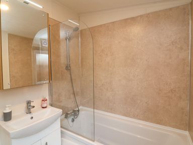 A bathroom with a white sink, mirrored cabinet, bathtub, and shower at Lodge 36 - Kingfisher Lodge in Wickhamford near Evesham