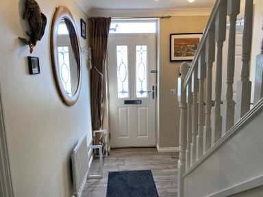 A hallway with a door and mirror at Harefield in Rothbury