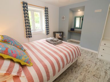 A bedroom with a bed and window at Sea View Loft in Rosudgeon