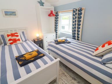 A bedroom with two beds and a wardrobe at Sea View Loft in Rosudgeon