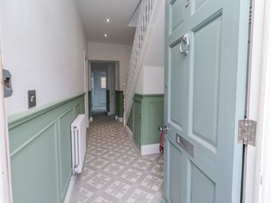A hallway with a door and stairs at 3 Lisburn Street Alnwick