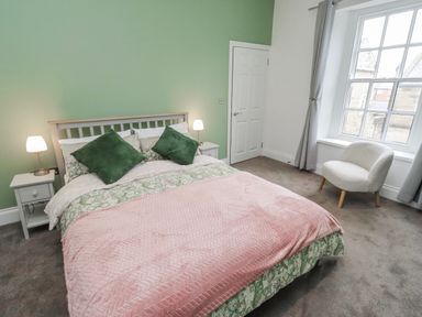 A bedroom with a bed and nightstands at 3 Lisburn Street Alnwick