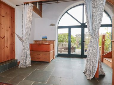 An entryway with a chest of drawers and glass doors at Stribleys Barn in Cusgarne near St Day