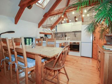 A kitchen with a dining table and chairs at Stribleys Barn Cusgarne near St Day