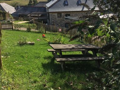 A garden with a picnic table and flowers at Stribleys Barn in Cusgarne