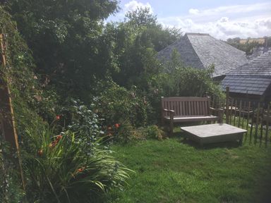 A garden with a bench and table at Stribleys Barn Cusgarne