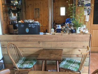 A cafe interior with a counter and seating area at Stribleys Barn in Cusgarne
