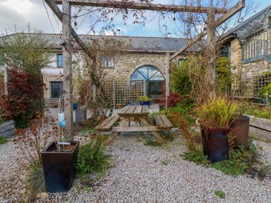 A garden with a picnic table and planters at Stribleys Barn Cusgarne, Truro