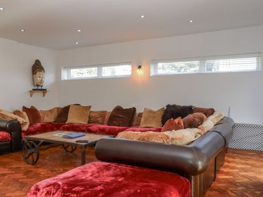 A living room with a large sofa and a table at Delmonte Lodge in Torquay