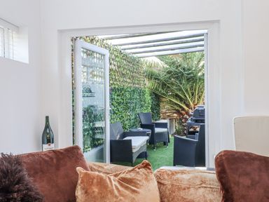 An outdoor patio with seating and plants at Delmonte Lodge in Torquay