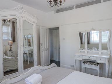 A bedroom with a mirror and dressing table at Delmonte Lodge in Torquay