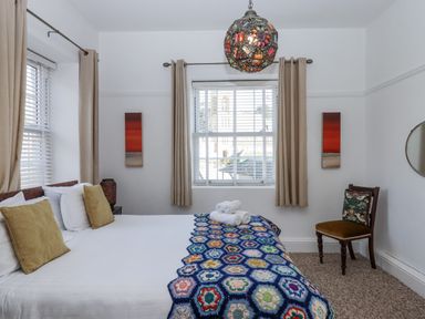 A bedroom with a bed and chair at Delmonte Lodge in Torquay