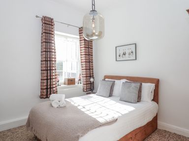 A bedroom with a bed and curtains at Delmonte Lodge in Torquay