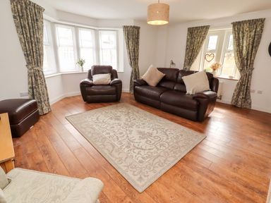 A living room with seating and a rug at The Lodge in Powburn