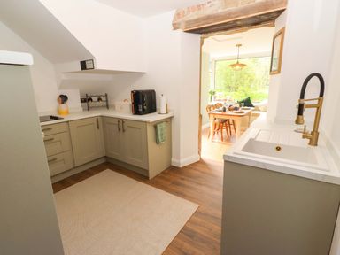A kitchen with cabinets and a sink at The Lodge in Powburn