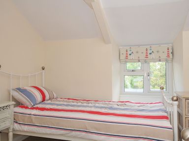 A bedroom with bed and window at 2 Porthilly Cottages Rock
