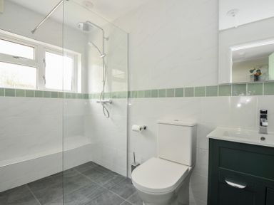 A bathroom with a shower, toilet, and sink at 2 Porthilly Cottages in Rock