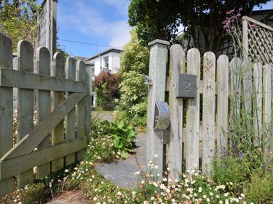 A garden entrance with a gate and floral arrangement at 2 Porthilly Cottages Rock