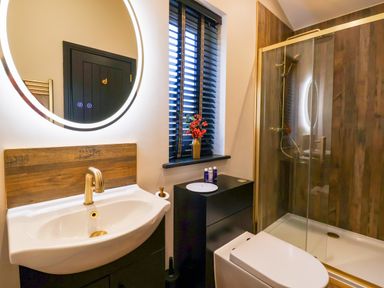 A bathroom with a sink faucet mirror shower and toilet at Routhorpe Lodge in Bainton near Great Driffield