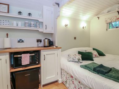 A bedroom with a kitchenette at Woodlands Retreat Shepherd's Hut Brundish near Laxfield