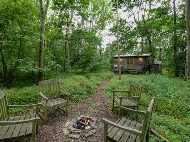 An outdoor space with chairs and a fire pit at Woodlands Retreat Shepherd's Hut in Brundish near Laxfield