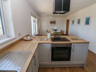 A kitchen with wooden countertops and an electric stove with oven at Arfryn in Solva